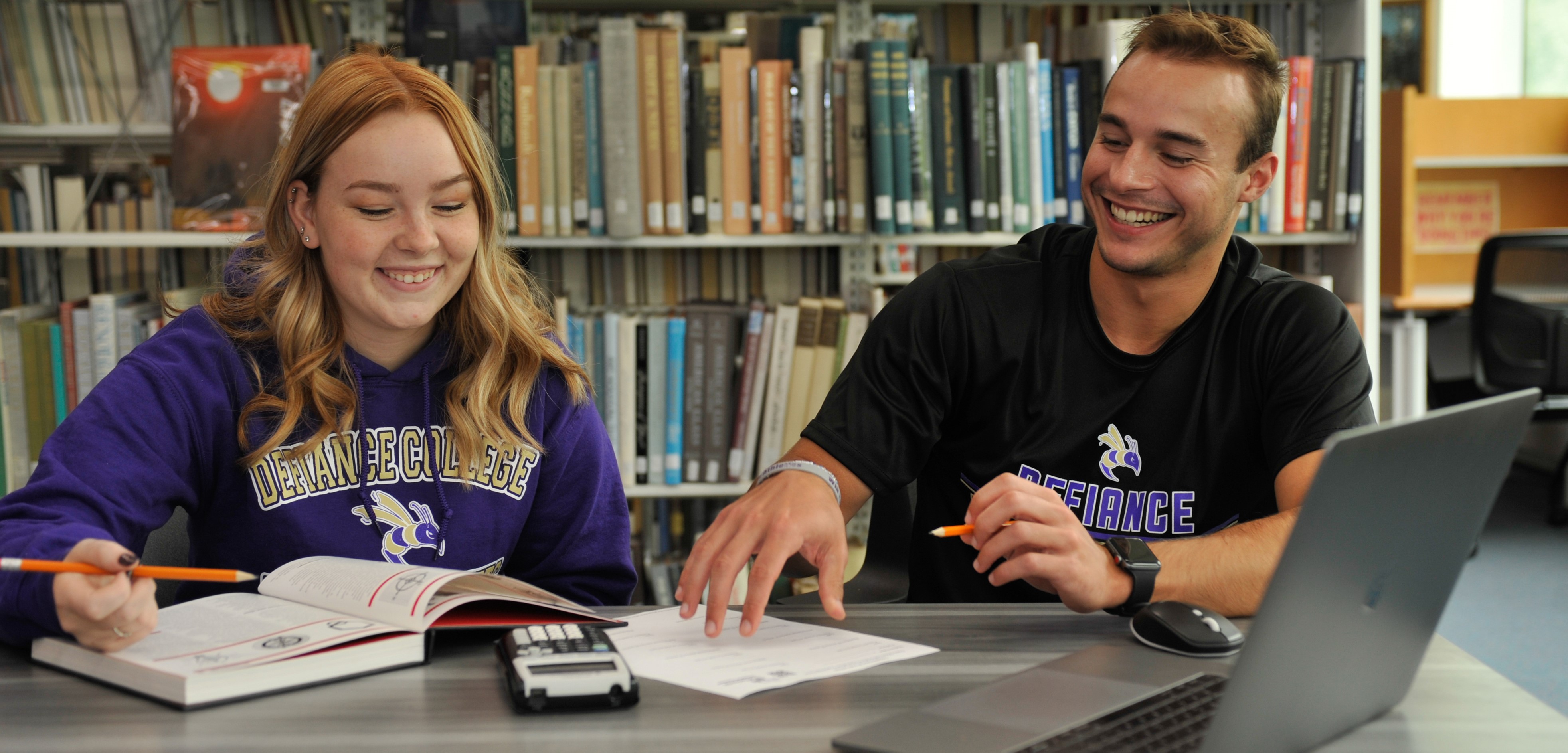 two students studying in the library together